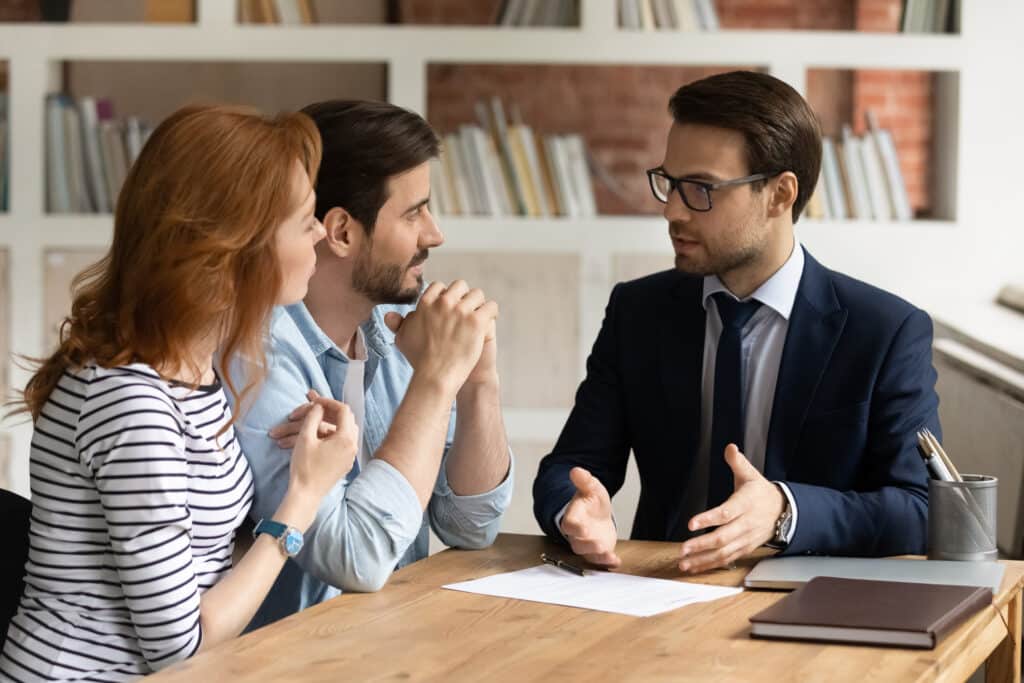 Interested young family couple visiting financial advisor in office. "A business man talking to a young couple