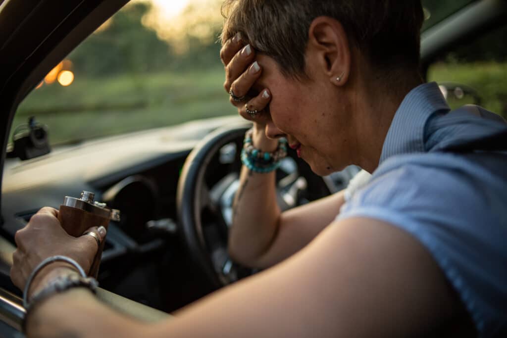 Disaster, drunk driver behind the wheel Woman leaning over the wheel of a car with her head in her hands